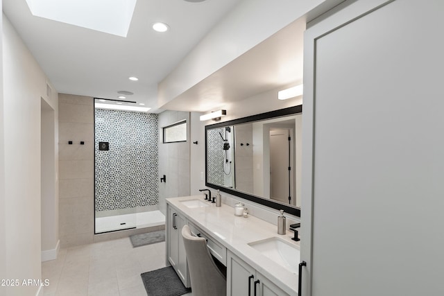 bathroom featuring vanity, tile patterned flooring, a skylight, and tiled shower