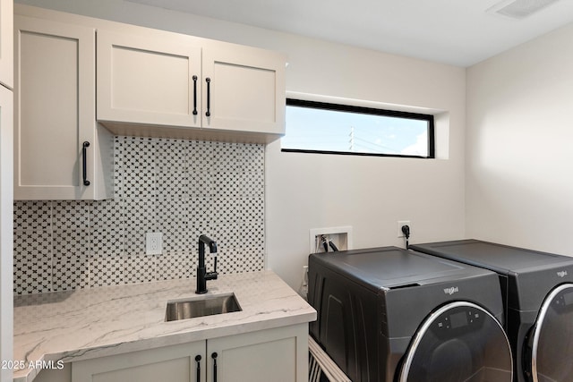 laundry area featuring cabinets, sink, and washing machine and clothes dryer