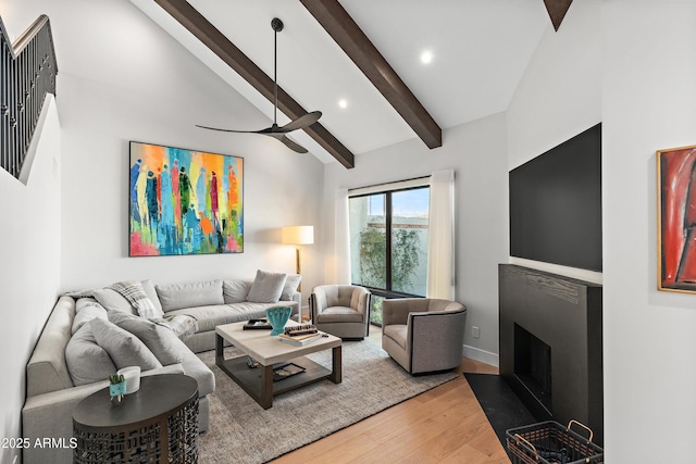 living room featuring lofted ceiling with beams, wood-type flooring, and ceiling fan