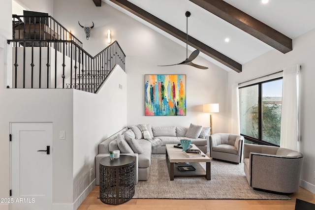 living room featuring beam ceiling, ceiling fan, hardwood / wood-style floors, and high vaulted ceiling