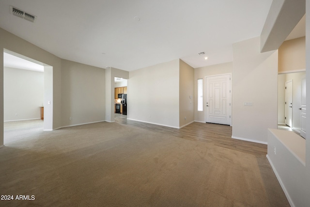 unfurnished living room with light carpet