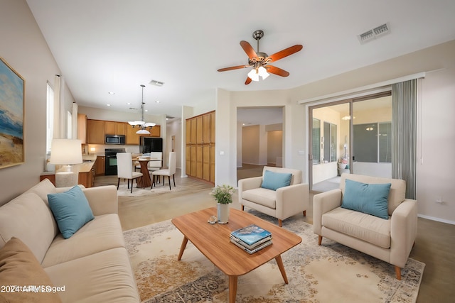 living room featuring ceiling fan with notable chandelier