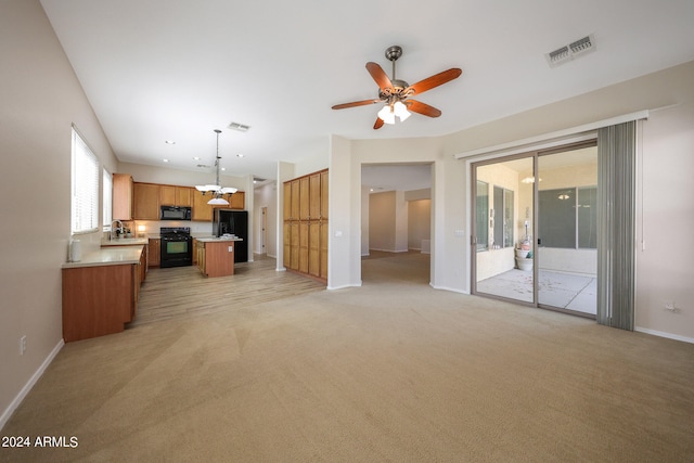 unfurnished living room featuring light colored carpet, sink, and ceiling fan with notable chandelier