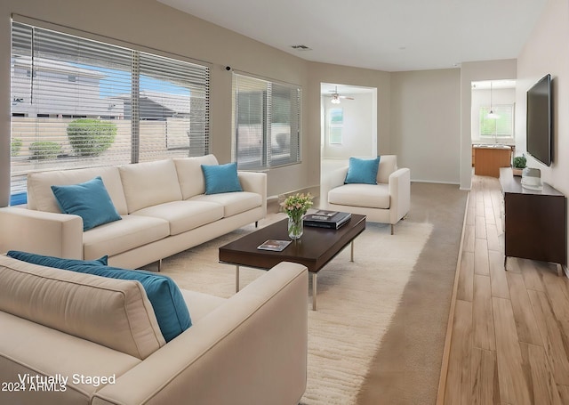 living room with a wealth of natural light, ceiling fan, and light wood-type flooring