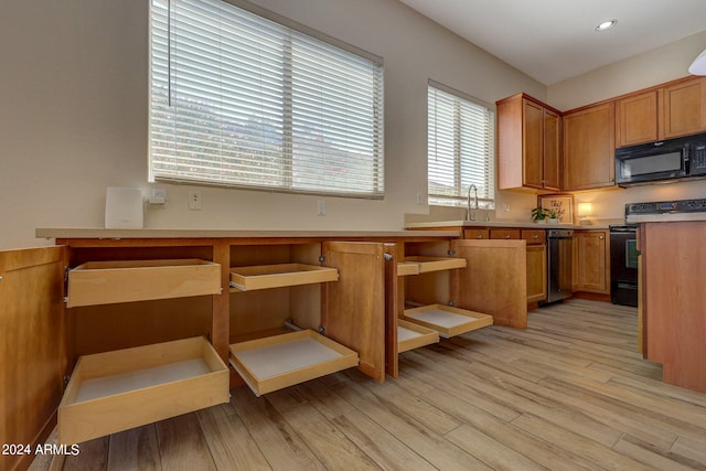 kitchen featuring light wood-type flooring, sink, and black appliances