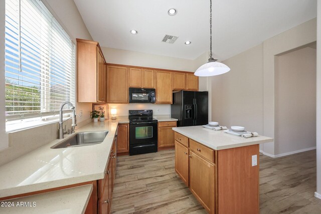 kitchen with a center island, black appliances, sink, light hardwood / wood-style flooring, and decorative light fixtures