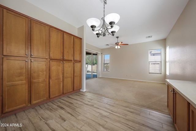 unfurnished dining area with light wood-type flooring and ceiling fan with notable chandelier