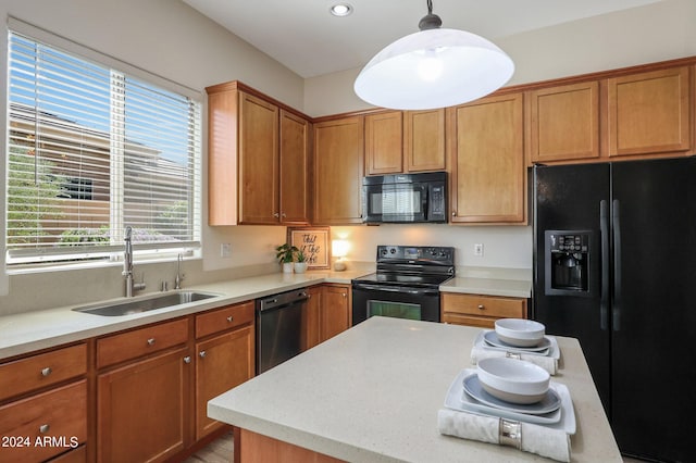 kitchen featuring black appliances, sink, and decorative light fixtures