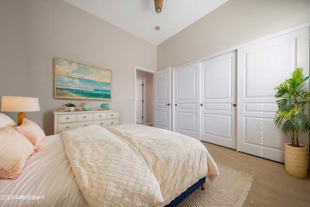 bedroom featuring high vaulted ceiling, light carpet, and a closet