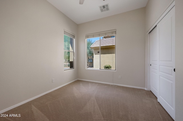 unfurnished bedroom with carpet floors, ceiling fan, and a closet