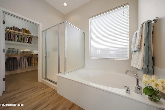 bathroom with hardwood / wood-style floors and independent shower and bath