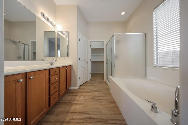 bathroom featuring shower with separate bathtub, vanity, and wood-type flooring