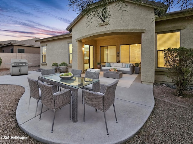 patio terrace at dusk featuring outdoor lounge area and grilling area