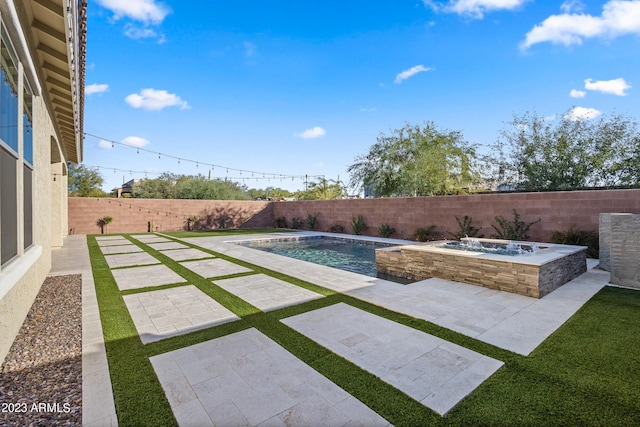 view of swimming pool featuring an in ground hot tub and a patio