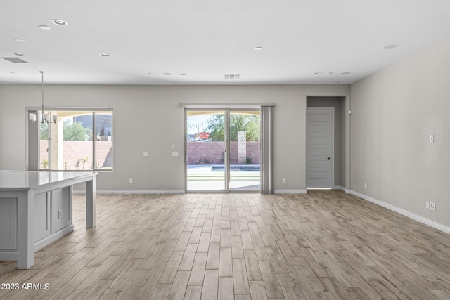 unfurnished living room featuring a notable chandelier