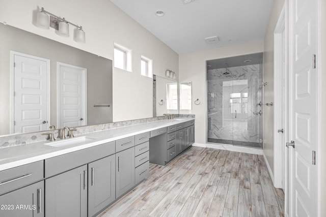 bathroom featuring wood-type flooring, vanity, and a shower with door