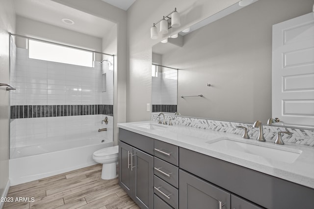 full bathroom featuring vanity, tiled shower / bath combo, and toilet