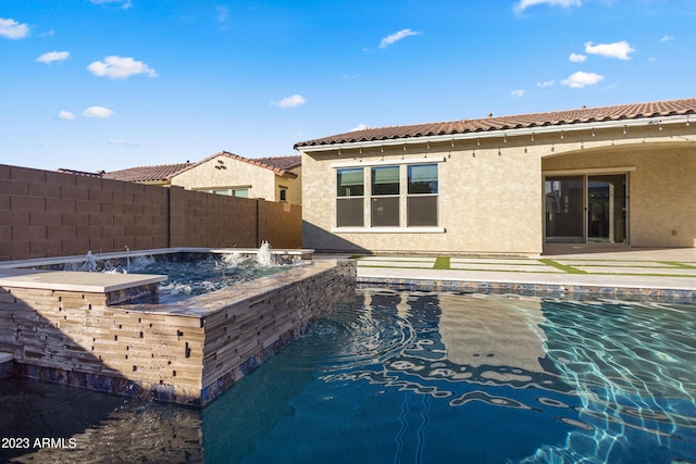 view of pool featuring pool water feature and a hot tub