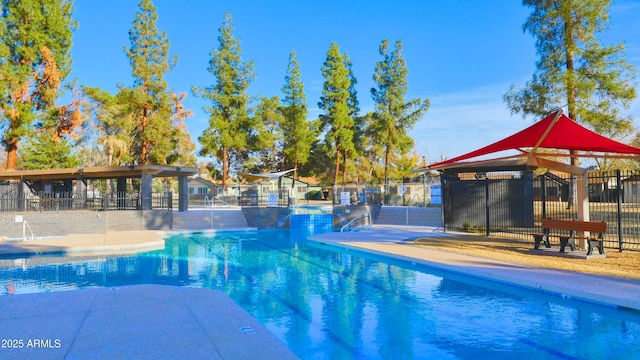 pool with a patio area and fence