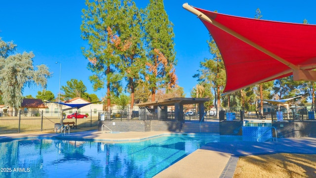 community pool with a patio area and fence