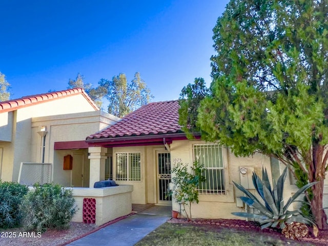 view of front facade with a tiled roof and stucco siding