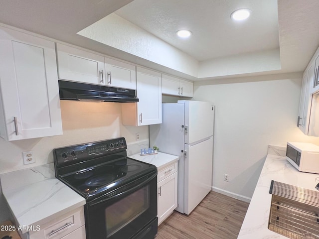 kitchen with white cabinets, under cabinet range hood, and white appliances