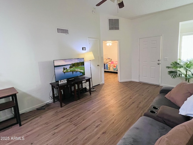 living area with a ceiling fan, baseboards, visible vents, and wood finished floors