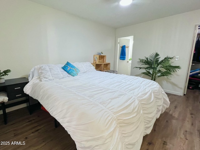 bedroom with baseboards and wood finished floors