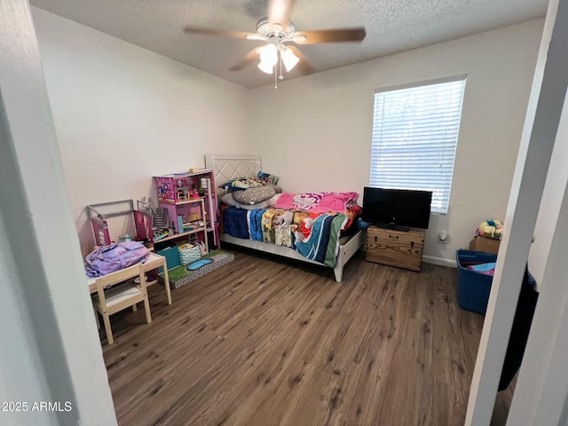 bedroom featuring a textured ceiling, wood finished floors, a ceiling fan, and baseboards