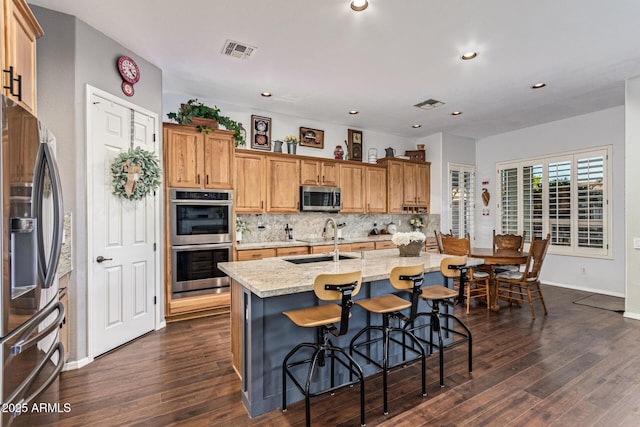 2045 E San Carlos Pl, Chandler, AZ 85249 - kitchen featuring appliances with stainless steel finishes, a sink, dark wood-type flooring, tasteful backsplash, and light stone countertops