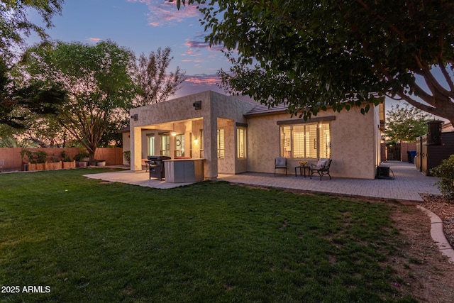 2045 E San Carlos Pl, Chandler, AZ 85249 - back of house at dusk featuring a hot tub, a patio, and stucco siding