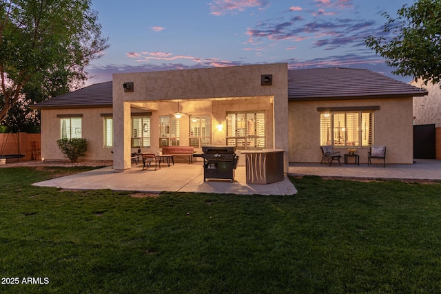 2045 E San Carlos Pl, Chandler, AZ 85249 - back of house at dusk featuring stucco siding, a patio area, and a tile roof