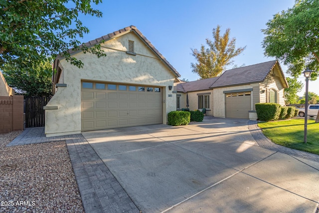 2045 E San Carlos Pl, Chandler, AZ 85249 - view of front facade featuring an attached garage, driveway, stucco siding, fence, and a gate