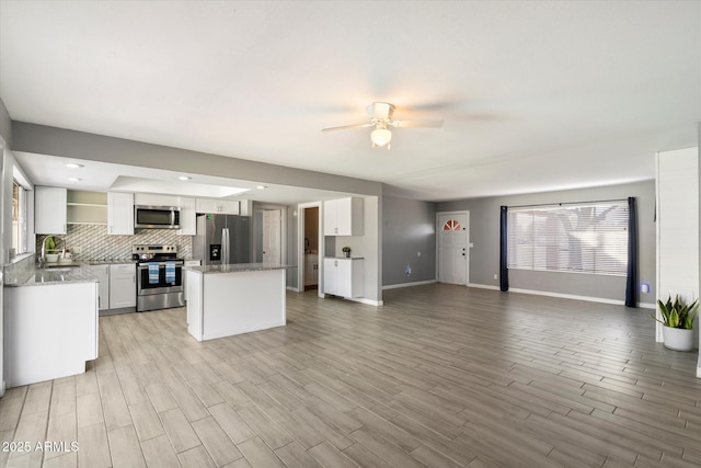 kitchen featuring sink, white cabinets, decorative backsplash, light hardwood / wood-style floors, and stainless steel appliances