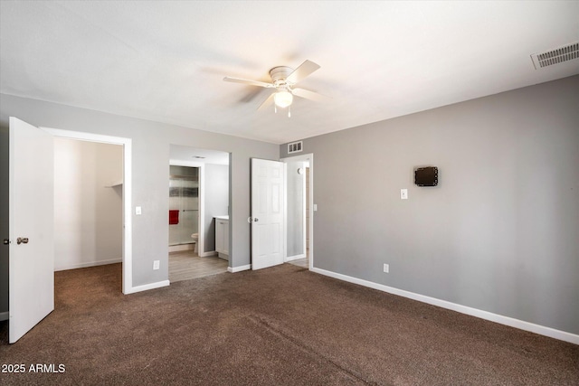 unfurnished bedroom with ceiling fan, carpet flooring, ensuite bath, and a baseboard radiator