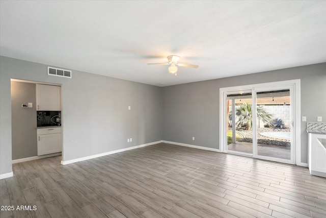 empty room featuring ceiling fan and light wood-type flooring