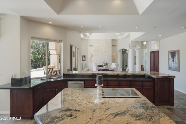 kitchen with a sink, baseboards, stone countertops, and recessed lighting