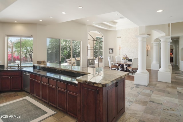 kitchen featuring a sink, dishwasher, arched walkways, recessed lighting, and decorative columns