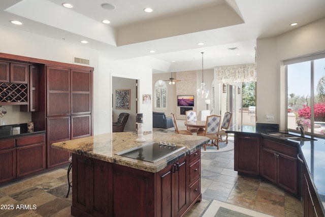 kitchen featuring stone tile flooring, visible vents, recessed lighting, black electric cooktop, and a tray ceiling