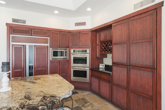 kitchen with visible vents, recessed lighting, built in appliances, and dark brown cabinets
