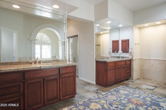 bathroom featuring recessed lighting, two vanities, and a sink