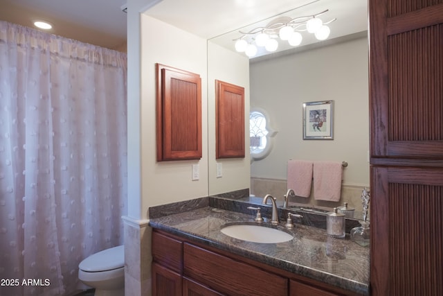 bathroom with toilet, curtained shower, and vanity
