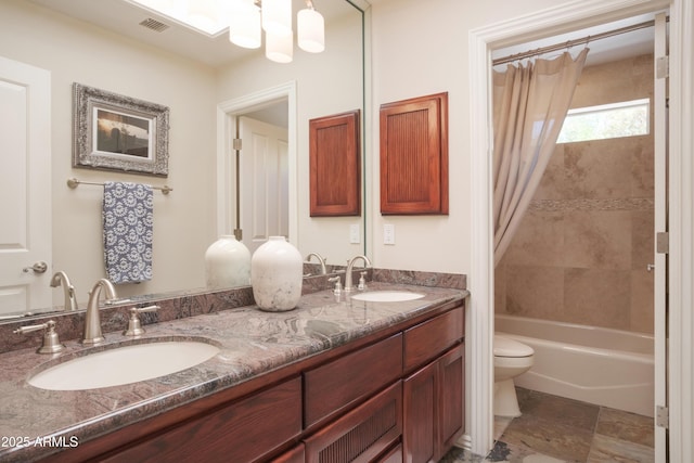 full bath with double vanity, toilet, visible vents, and a sink