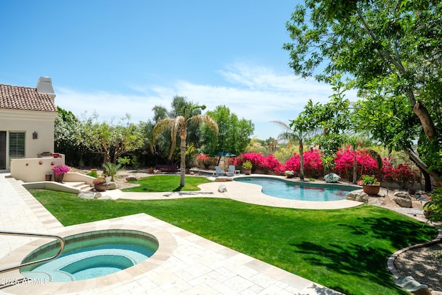 pool with a lawn, a patio, and an in ground hot tub