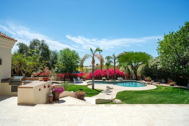 pool featuring a yard, exterior kitchen, a patio, and a grill