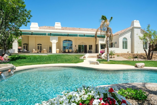 rear view of house with french doors, a chimney, an outdoor pool, a patio area, and stucco siding