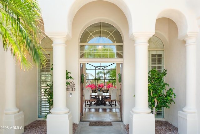 entrance to property featuring a porch and stucco siding