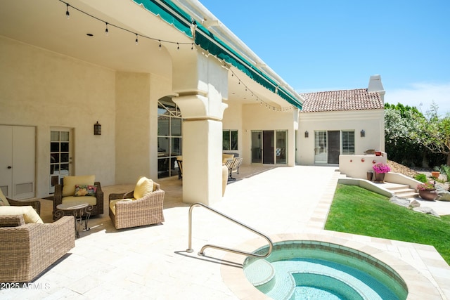 back of property featuring a patio, outdoor lounge area, stucco siding, and an in ground hot tub