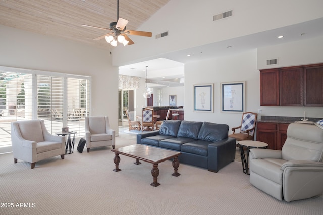 living room with visible vents, a ceiling fan, and light carpet