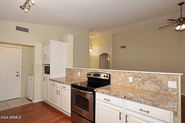 kitchen with backsplash, a textured ceiling, ceiling fan, white cabinets, and stainless steel range with electric cooktop